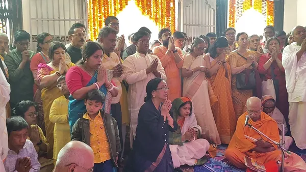 Festivals & Observances: Devotees standing with folded hands as a monk conducts a ritual